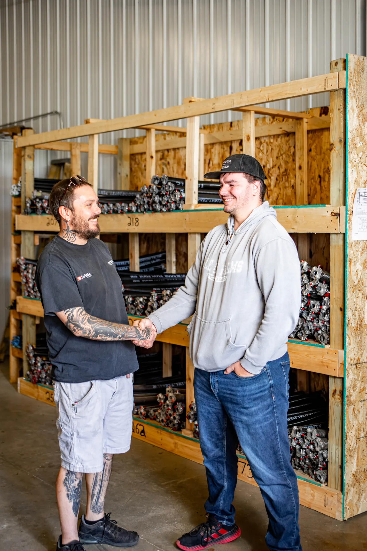 Two garage door technicians holding hand in front a spring garage doors